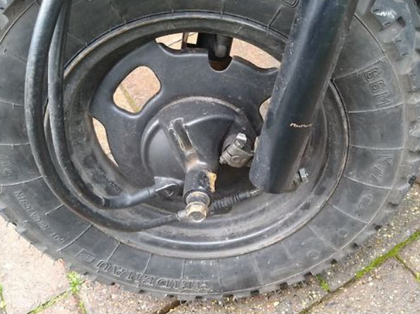 Close-up of a black tire with visible tread pattern on a concrete surface.