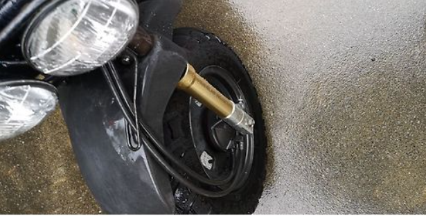 Close-up of a motorcycle tire with a visible tread pattern on a textured surface.