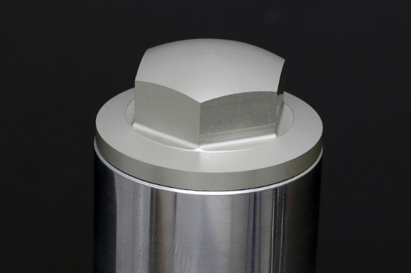 Metallic cylindrical component with hexagonal fitting on a black background