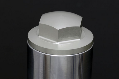Metallic cylindrical component with hexagonal fitting on a black background