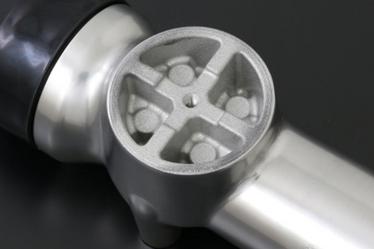 Close-up of a metallic kitchen tool with a textured surface on a dark background