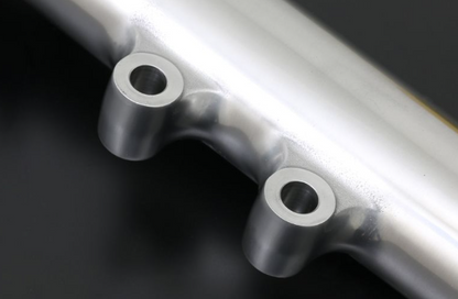 Close-up of a metallic pipe with circular openings on a dark background