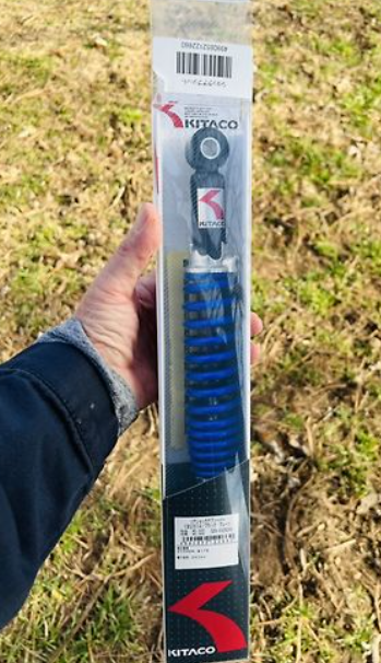 KITACO product held by a person outdoors on grass