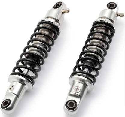 Two motorcycle shock absorbers on a white background