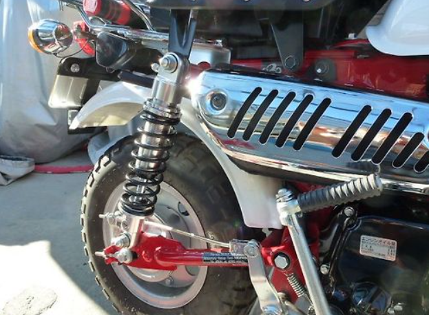 Close-up of a motorcycle's suspension system with a focus on the shock absorber and spring.