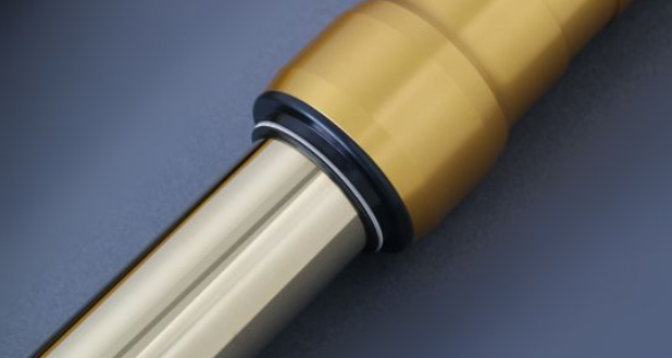 Close-up of a beige handle with a metallic shaft on a dark blue background