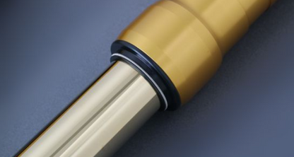 Close-up of a beige handle with a metallic shaft on a dark blue background