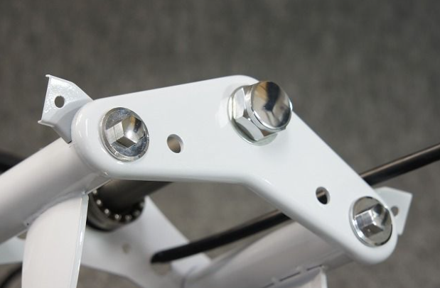 Close-up of a white metal bracket with screws on a blurred background