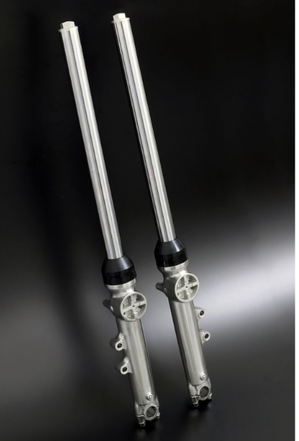 Two metallic shock absorbers on a dark background