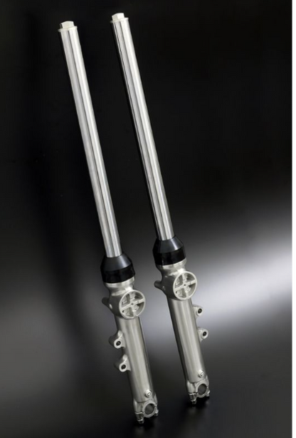 Two metallic shock absorbers on a dark background