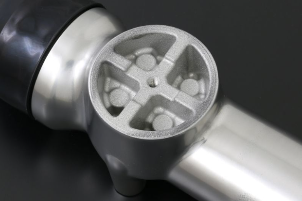 Close-up of a metallic object with a textured surface on a dark background