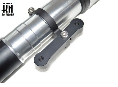 Close-up of a motorcycle suspension fork with 'Kobe' branding on a white background