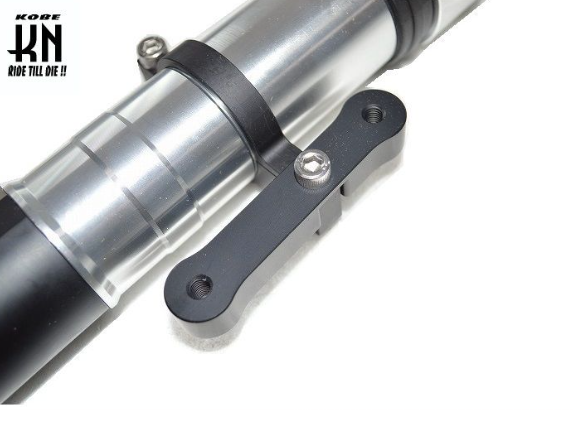 Close-up of a motorcycle suspension fork with 'Kobe' branding on a white background
