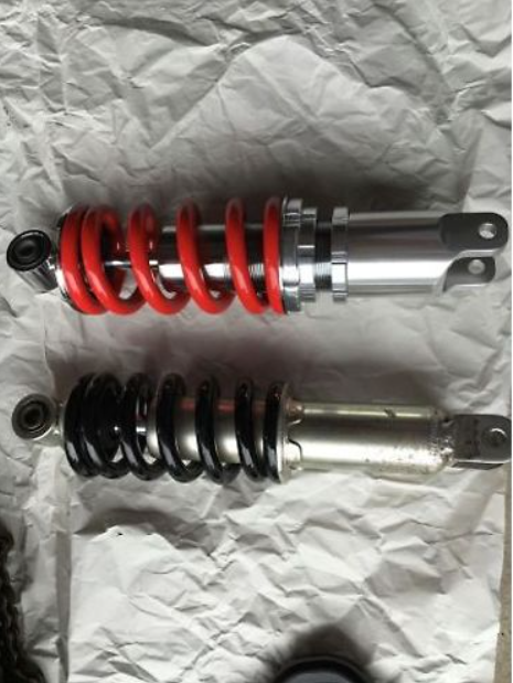 Two shock absorbers on a crumpled white paper background