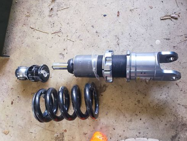 Motorcycle shock absorber and spring on a concrete floor