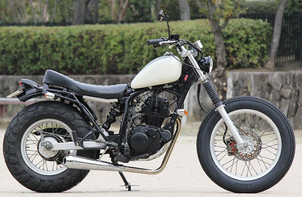 White motorcycle parked on a paved surface with a natural background