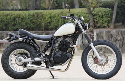 White motorcycle parked on a paved surface with a natural background