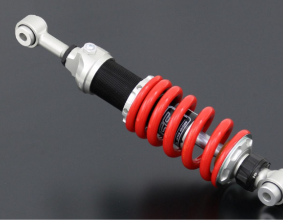 Shock absorber with red coil spring on a gray background
