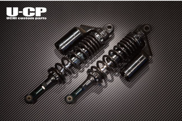 Two shock absorbers on a carbon fiber background with U-CP branding.