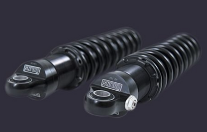 Two black shock absorbers with 'Savage' branding on a dark background