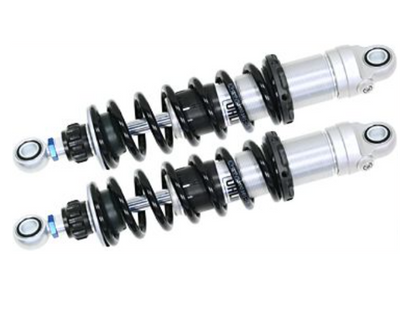 Two motorcycle shock absorbers on a white background