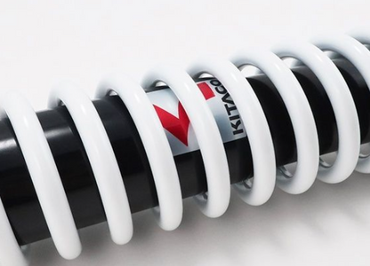 Close-up of a coil spring with Kit Carson logo on a white background