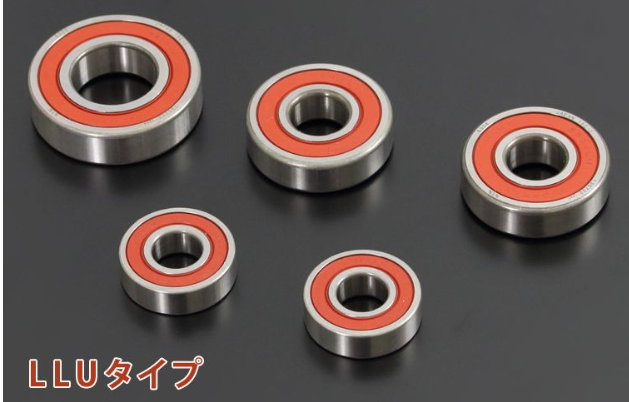 Five metal bearings with red inner races on a black background