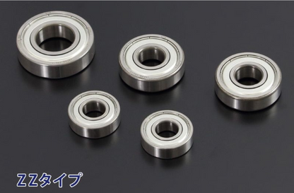 Five metal bearings of different sizes on a dark background
