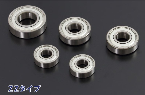 Five metal bearings of different sizes on a dark background
