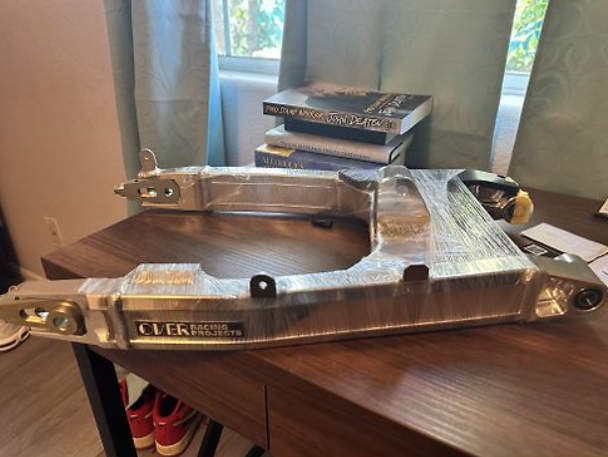 Metal workbench vise on a wooden table with books in the background