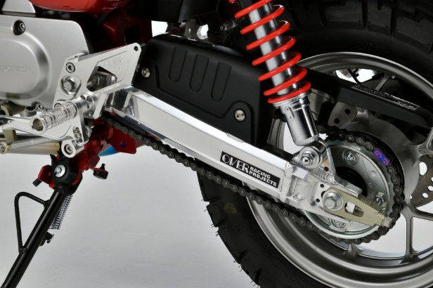 Close-up of a motorcycle chain and sprocket system on a gray background