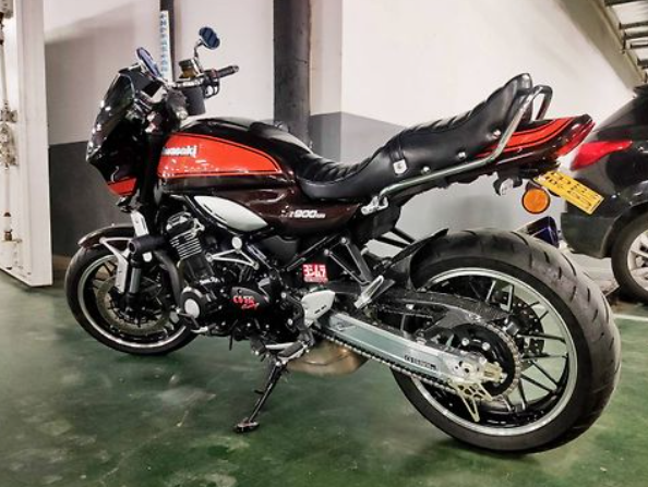 Black and red motorcycle parked indoors on a green floor.