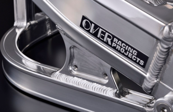 Metallic component with 'Over Racing Projects' branding on a dark background
