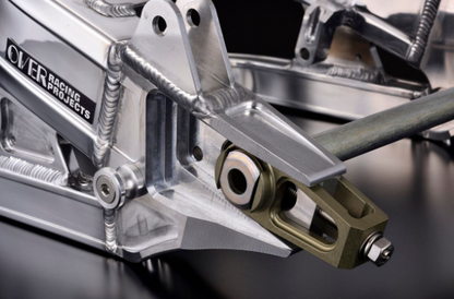 Close-up of a metallic mechanical component with 'Over Raging Projects' branding on a dark background.