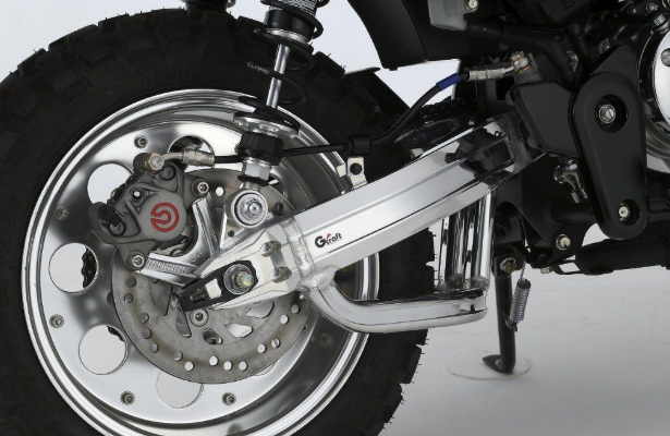 Close-up of a motorcycle wheel and suspension system on a white background