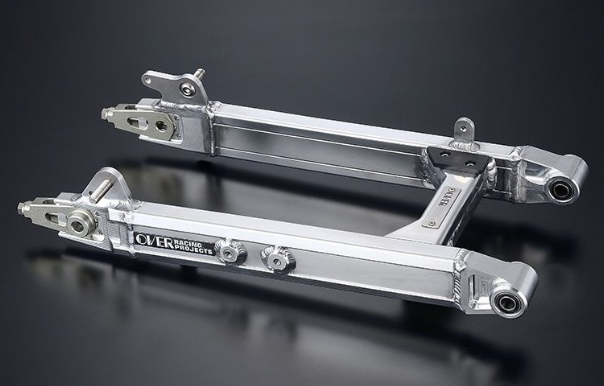 Two metallic suspension links on a dark background