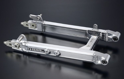 Two metallic suspension links on a dark background