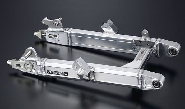 Two metal suspension links on a reflective black surface