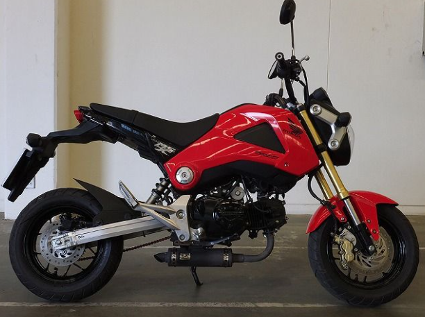 Red and black motorcycle parked indoors with a neutral background