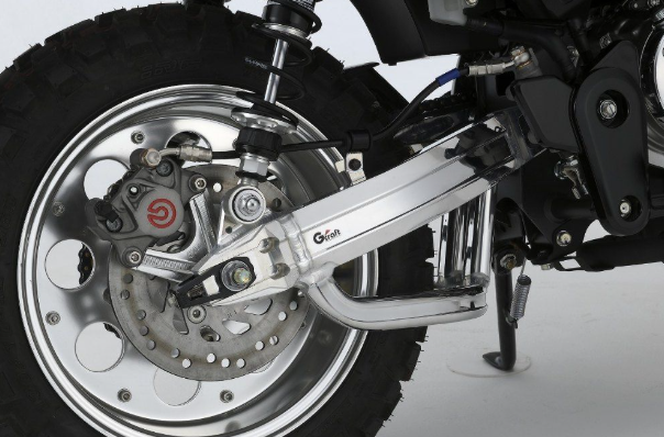 Close-up of a motorcycle wheel and suspension system on a white background