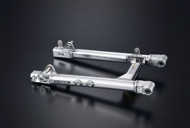 Pair of silver metal foot pegs on a reflective black surface