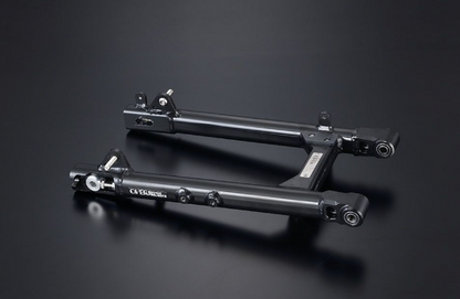Two black metal components on a dark background