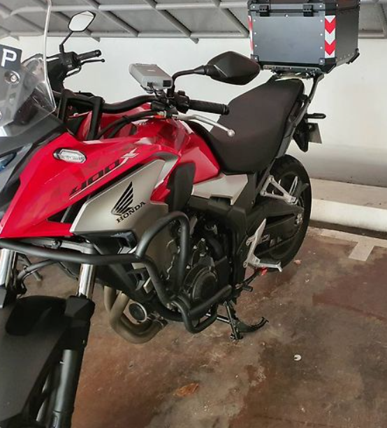 Red and black Honda motorcycle with a storage box in an indoor setting
