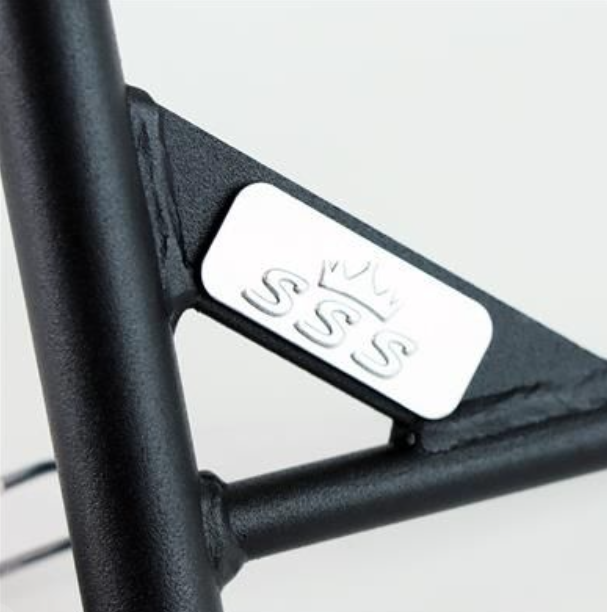 Close-up of a black metal frame with a silver label featuring 'SSS' on a white background.
