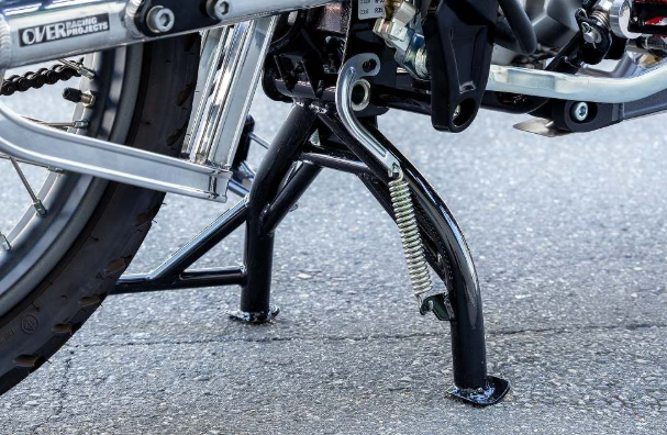 Close-up of a motorcycle kickstand on a pavement
