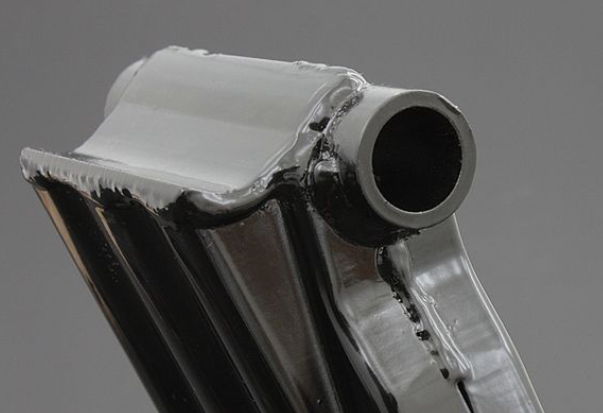 Metallic exhaust pipe on a gray background