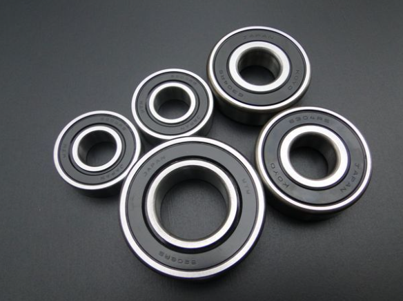 Five metal bearings on a dark gray background