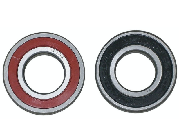 Two bearings, one red and silver, the other black and silver, on a white background.
