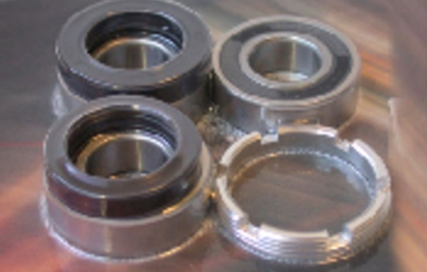 Four metal bearings on a reflective surface