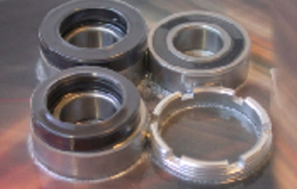 Four metal bearings on a reflective surface